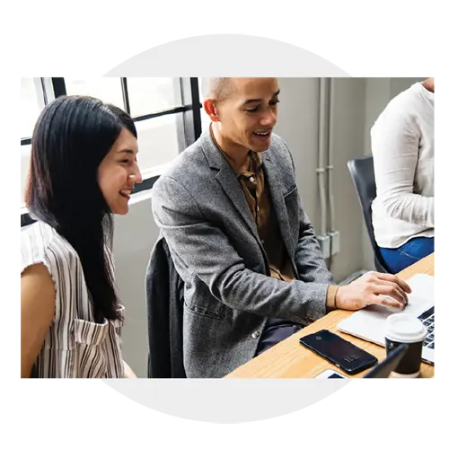 An image of a woman and a man working together on a laptop.